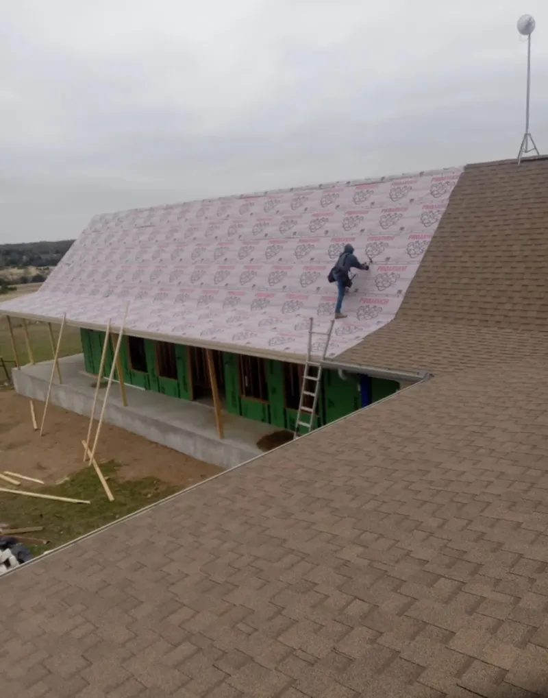 Worker preparing underlayment for a metal roof installation in Newberry
